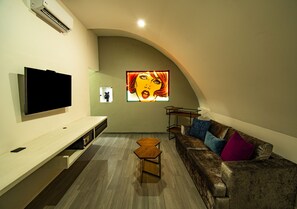 Suite de lujo, 1 cama de matrimonio grande, no fumadores | Zona de estar | Smart TV de 32 pulgadas con canales por cable, una televisión