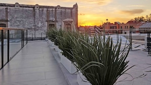 A rooftop terrace with a view of a historic building and sunset. - La Casona que Encanta (Querétaro)