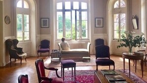 A spacious room with a large window, a sofa, and a radiator. - Large Italian villa with its park, swimming pool and tennis court (Saint-Étienne-De-Mer-Morte)