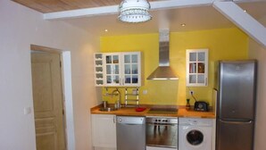 Una cucina compatta con lavastoviglie, forno, lavatrice e frigorifero.