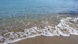 Una playa con agua cristalina y olas suaves.
