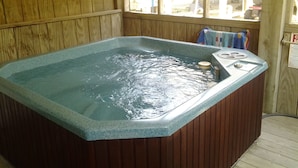 Een hottub met een houten binnenkant en uitzicht door een raam.