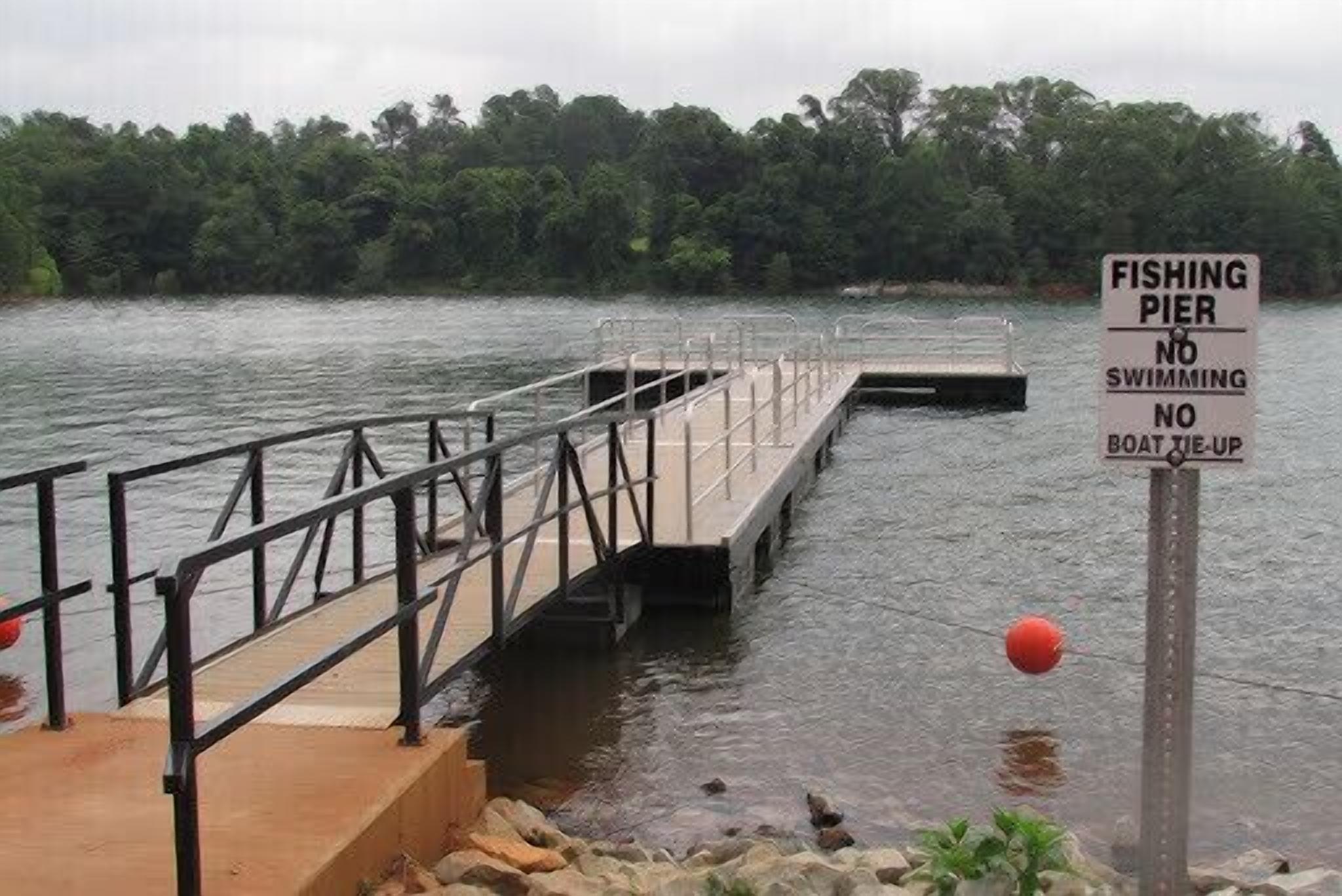 Un muelle de pesca con un cartel que indica prohibido bañarse y atracar barcos.