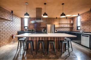 Refrigerador em uma área comum, talheres/pratos/utensílios de cozinha