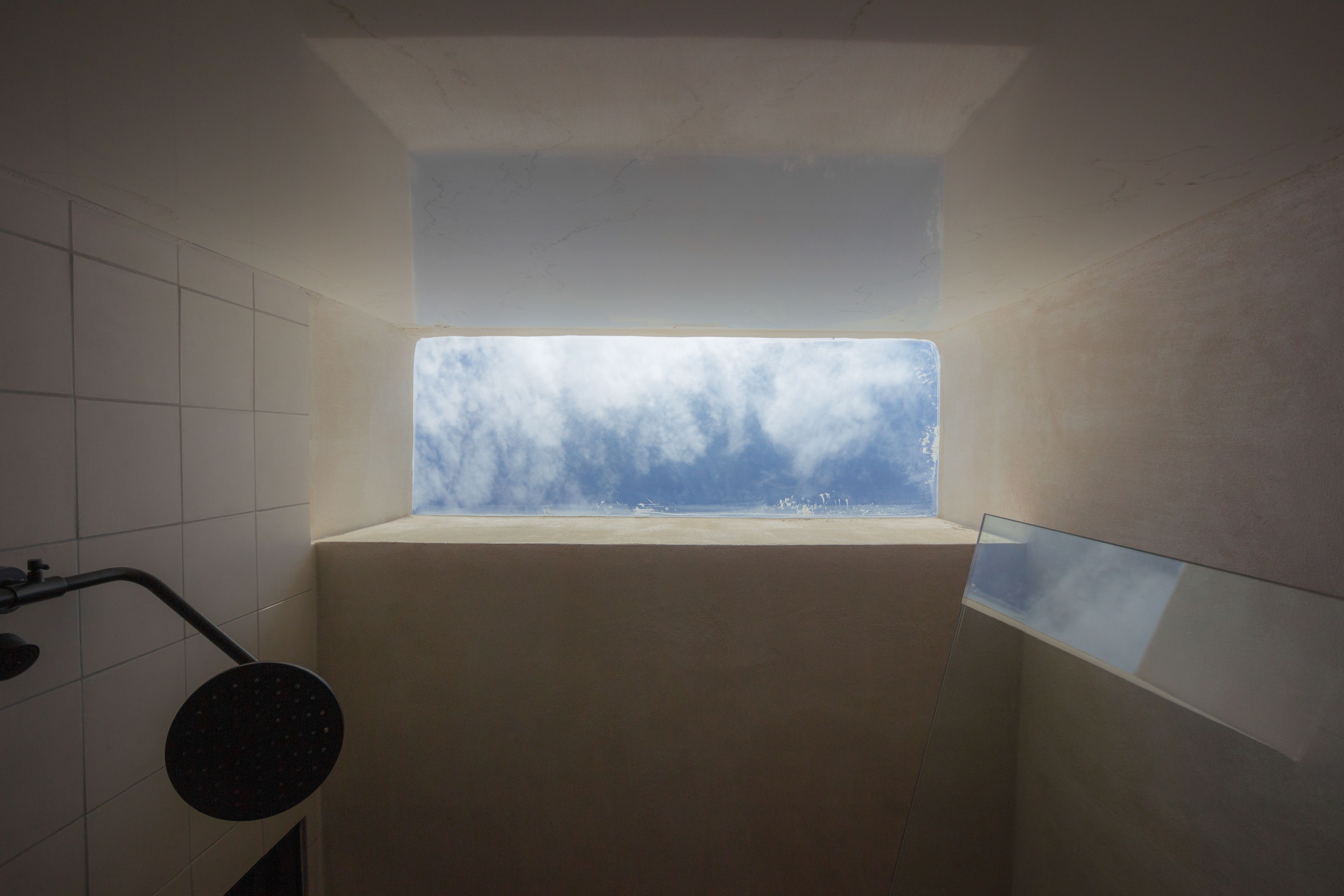 Un baño con tragaluz, bañera y ducha.