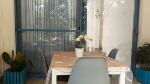 Un coin repas avec une table, des chaises et un cactus.