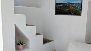 Un escalier blanc avec une petite plante en pot sur le palier.