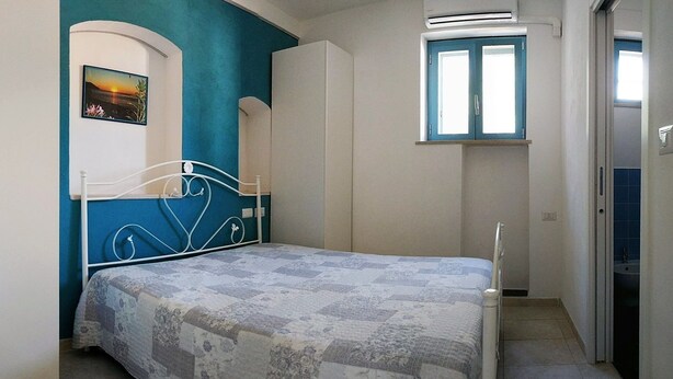 Une chambre à coucher avec un lit, une fenêtre et une porte.