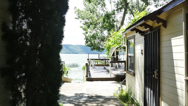 Eine Blockhütte am See mit Terrasse, Sitzgelegenheit im Freien und Seeblick.