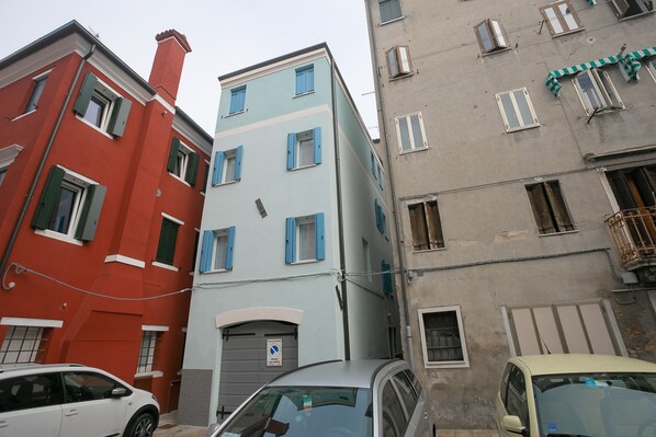 A narrow street with buildings of different heights and colors.