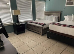 A bedroom with two beds, a nightstand, a lamp, and a desk with a keyboard. - 2330/B Comfy 2 bed dual master with Backyard! (San Diego)