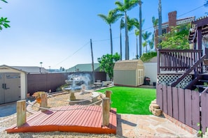A backyard with a fire pit, a wooden deck, a fenced area, and a small shed. - 2330/B Comfy 2 bed dual master with Backyard! (San Diego)