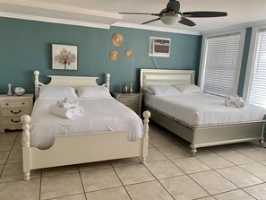 A double room with two beds, a ceiling fan, a window with blinds, and a wall-mounted air conditioning unit. - 2330/B Comfy 2 bed dual master with Backyard! (San Diego)