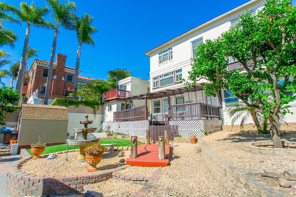 A courtyard with a fountain, potted plants, and a wooden deck. - 2330/B Comfy 2 bed dual master with Backyard! (San Diego)