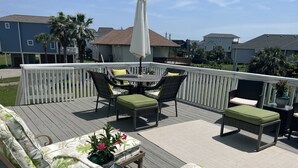 En terrasse med udendørs møbler, herunder en sofa, stole og et bord.