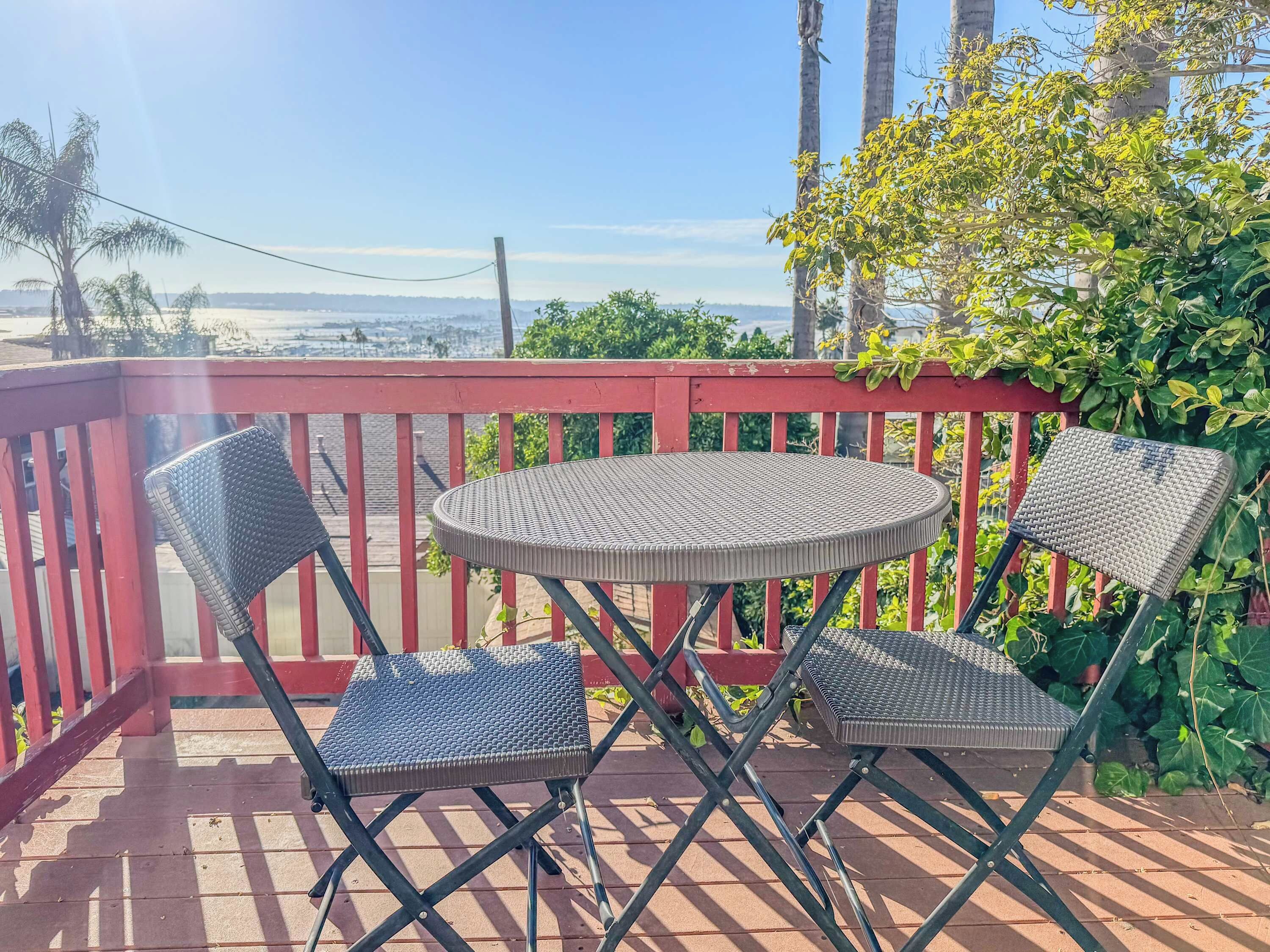 Une petite terrasse extérieure avec une table ronde et deux chaises.