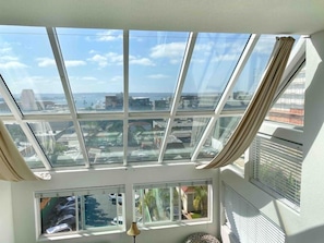 A room with a large skylight and multiple windows offering views of the cityscape. - 301 Amazing Sky Loft in Little Italy! (San Diego)