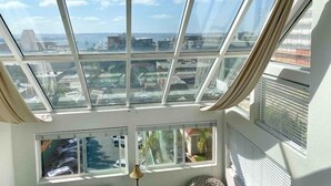 Una habitación con un tragaluz grande y múltiples ventanas que ofrecen vistas de la ciudad.