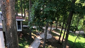 A pathway through a wooded area with a small structure and a bench. -  Activity all around!  stay up in the trees, Take in the activity or just chill
 (Glasgow)
