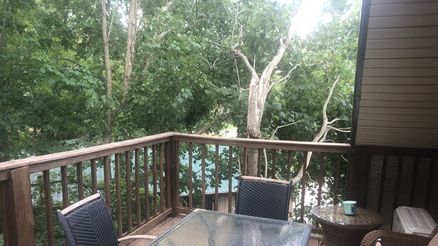 A wooden deck with a glass table and two wicker chairs, surrounded by trees. -  Activity all around!  stay up in the trees, Take in the activity or just chill
 (Glasgow)