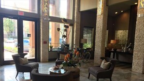 Una hall con reception, area salotto e una bicicletta parcheggiata vicino alla finestra.