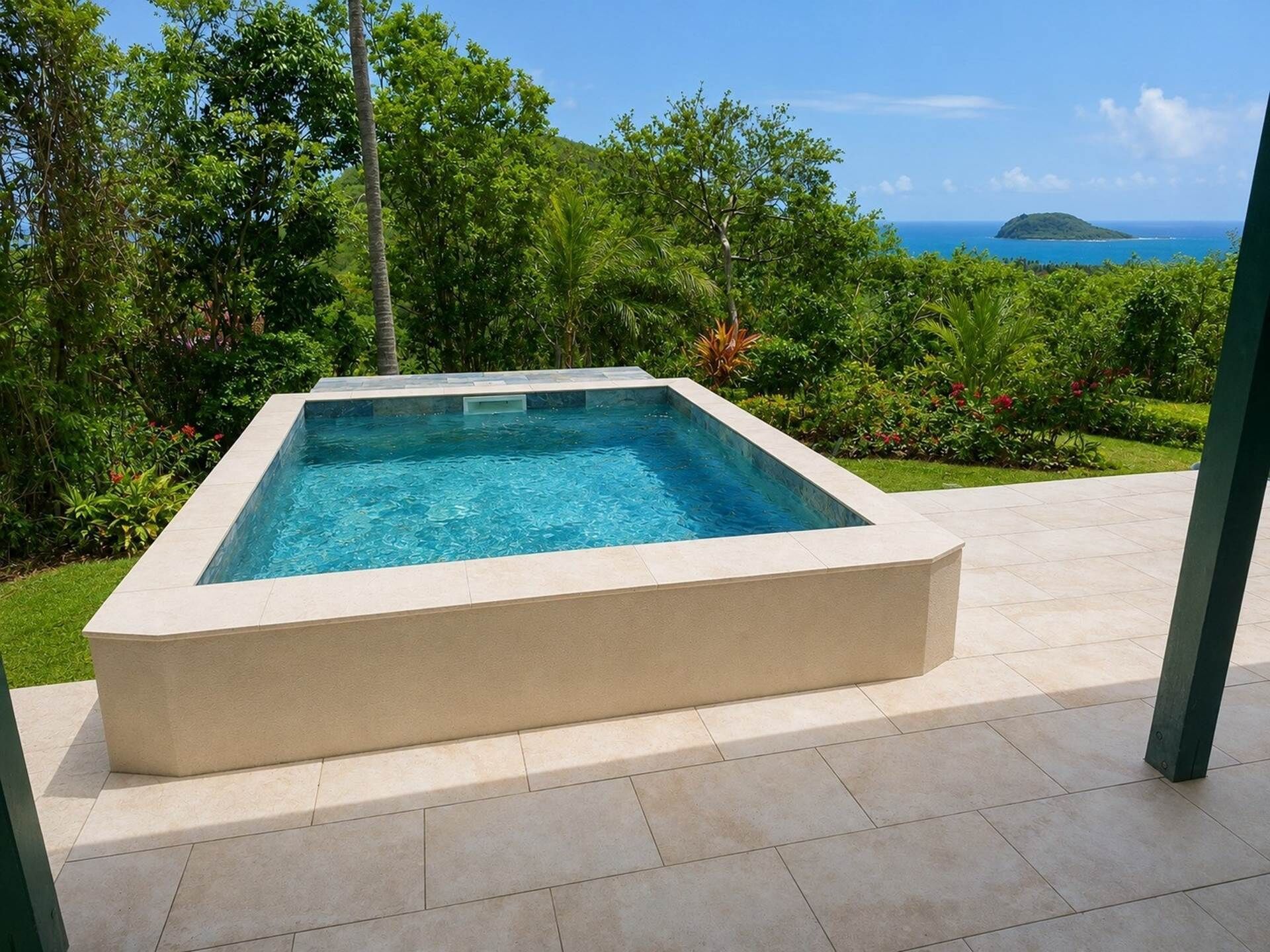 A rectangular pool with clear blue water, surrounded by lush greenery and a view of the ocean.