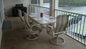 A balcony with a table and chairs, overlooking a body of water. - 6102 Towers. Luxury 6th Floor Towers, Beautifully Decorated. Free Wifi (Osage Beach)