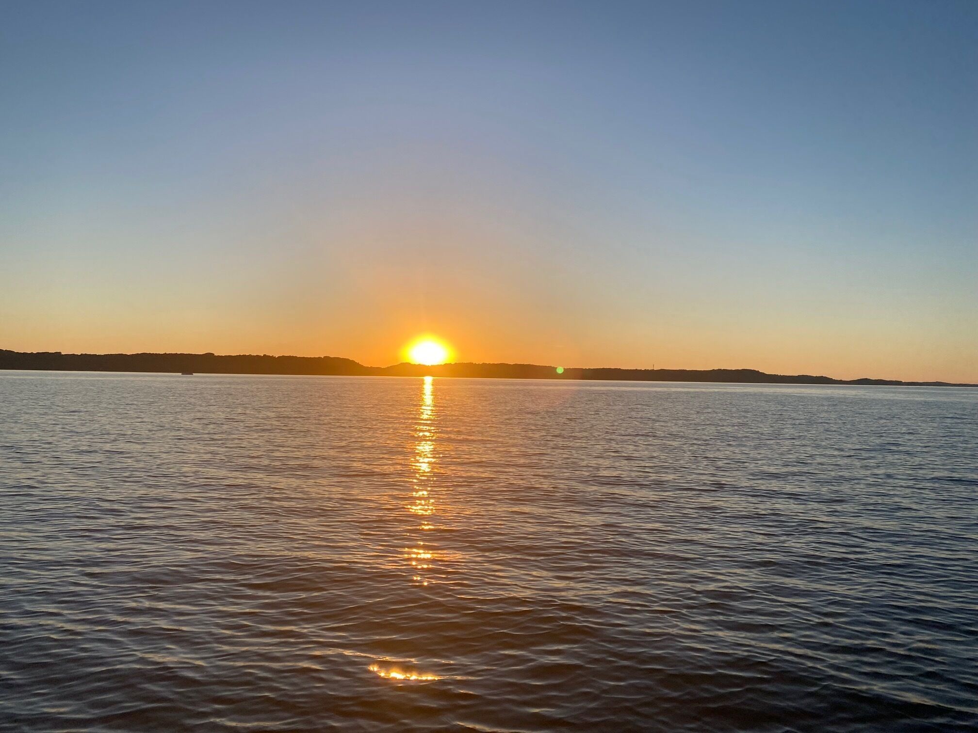 A calm body of water reflecting the sun.