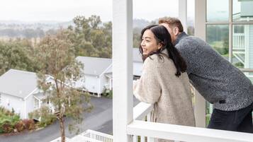 A balcony with a view of houses and greenery.