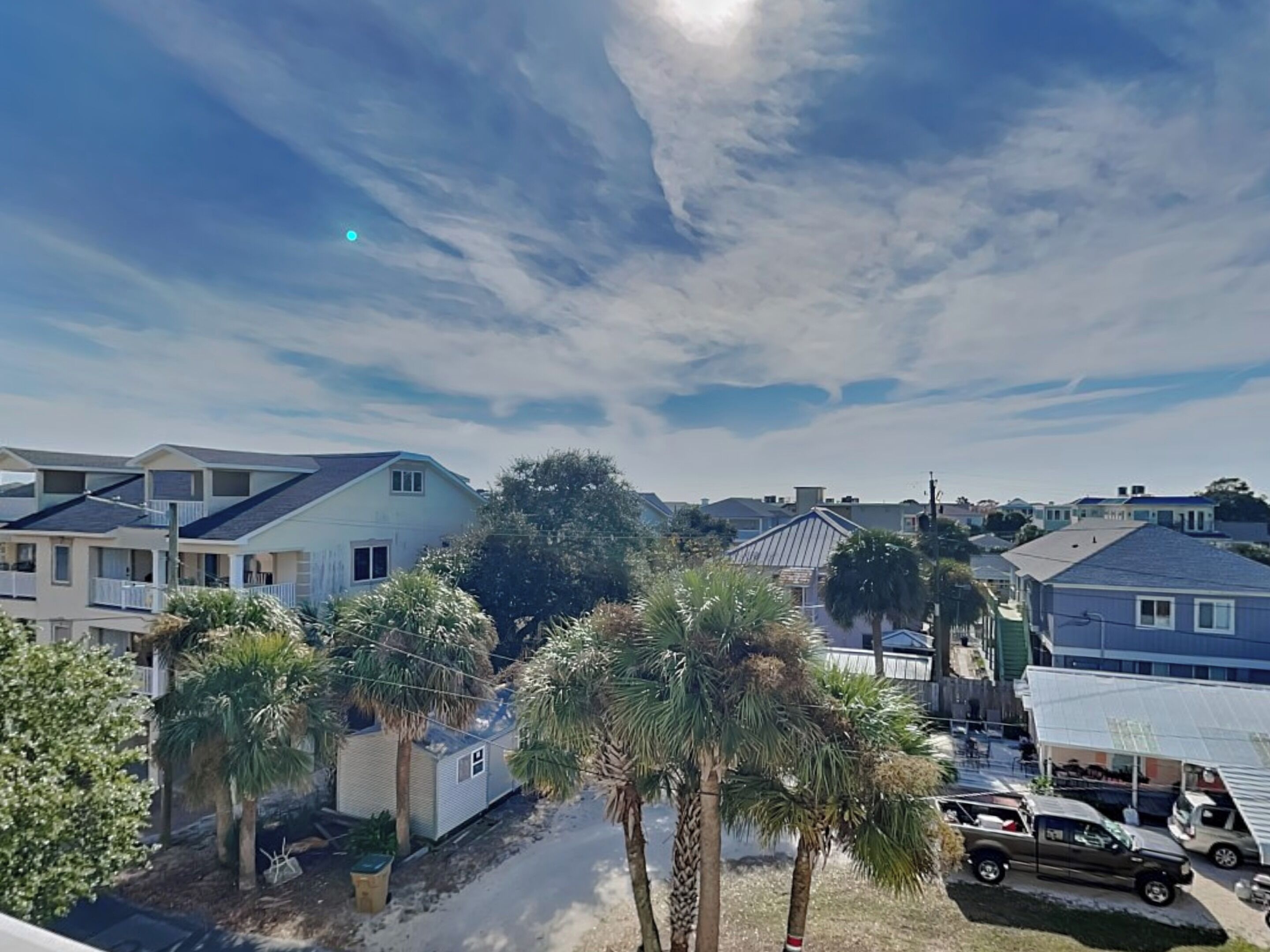 Zona residencial con varias casas, algunas con garajes incorporados, y palmeras.