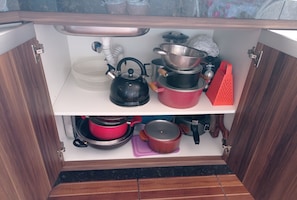 Kitchen essentials at your fingertips, with a kettle, pot, colander, and grater within easy reach.