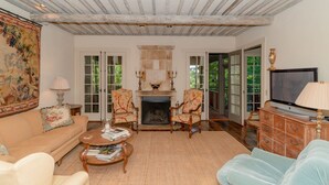 Una sala de estar acogedora con chimenea, asientos cómodos y televisor.
