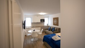 Ein modernes Apartment mit Küchenzeile, Essbereich und Wohnbereich.