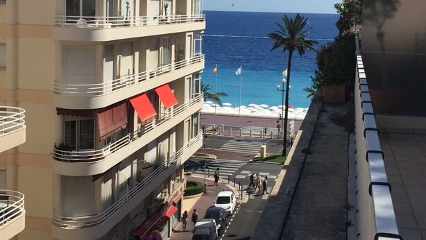 Ett hotell med flera våningar och balkonger med utsikt över en strand.