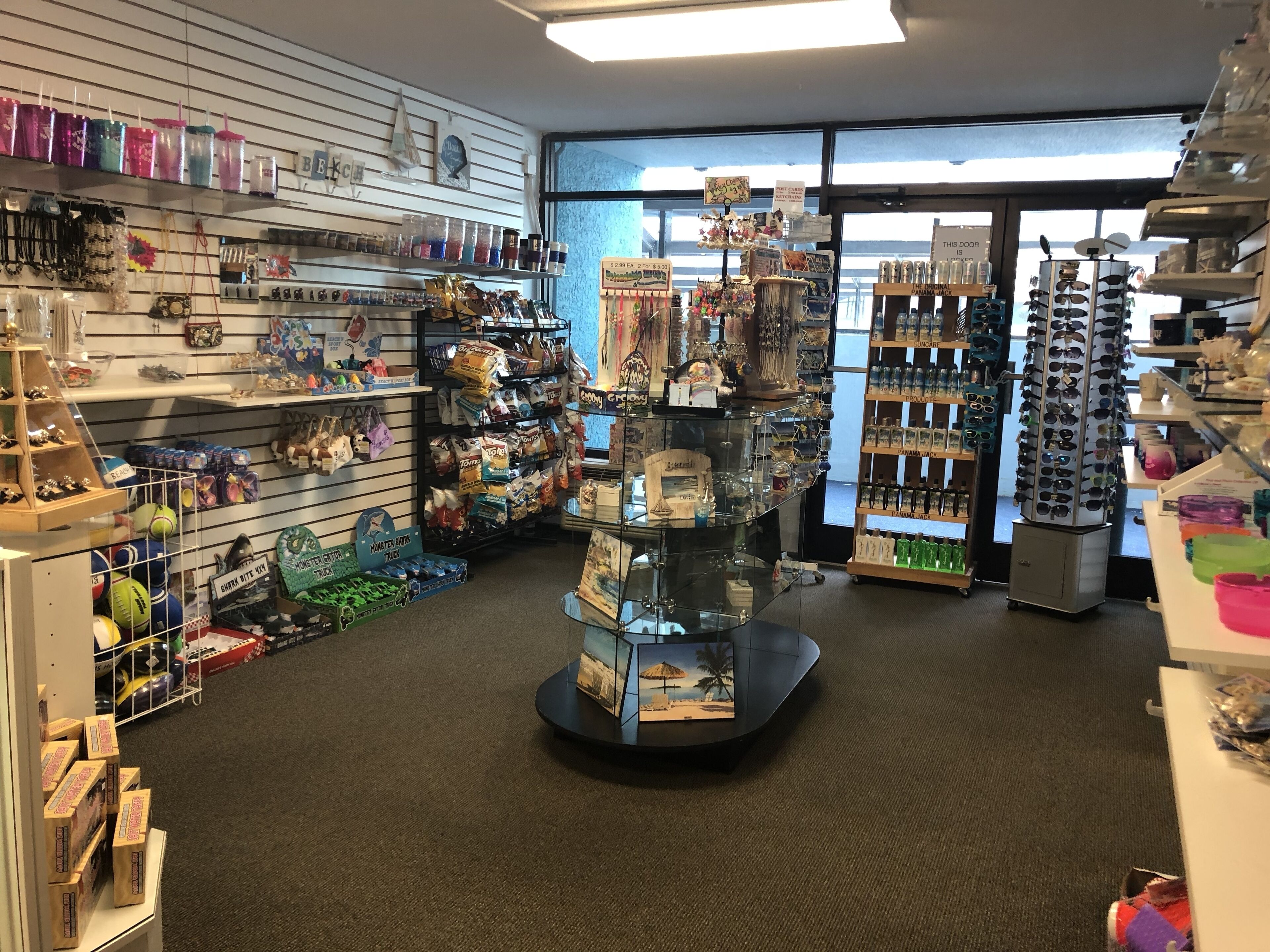 A store with shelves of various items including snacks, sunglasses, and decorative objects.