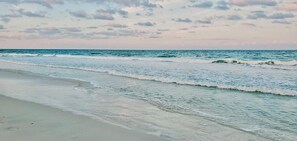 A beach with gentle waves and a clear sky.