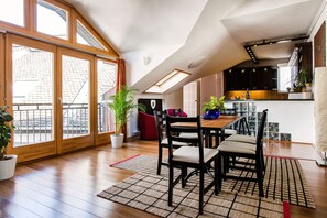 A modern kitchen with dark cabinets, a wooden dining table, and a skylight. - Cecile's Cosy, downtown aptmnt on gastro street 3 minutes to the Central Market (IX. kerület)