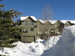 A two-story building with a green exterior and a garage. - Big End Unit, Deck! Near Lake Trail. Easy Drive to Dining, Activities, Events (Frisco)