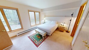 A bedroom with a bed, bedside tables, a lamp, a heater, and a window. - Big End Unit, Deck! Near Lake Trail. Easy Drive to Dining, Activities, Events (Frisco)