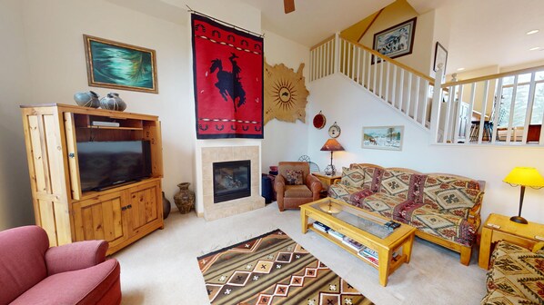 A living room with a TV, sofa, armchair, fireplace, and a staircase. - Big End Unit, Deck! Near Lake Trail. Easy Drive to Dining, Activities, Events (Frisco)