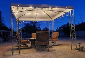 Relax in this serene outdoor seating area with two comfortable chairs and a small table.