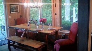 Ein Holzespeisetisch mit einer Bank, einem roten Stuhl und einer Chandelüstere.