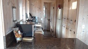 Eine Küche mit Granit Arbeitsplatten, Holzschränken und einer Kochinsel mit Hockern.