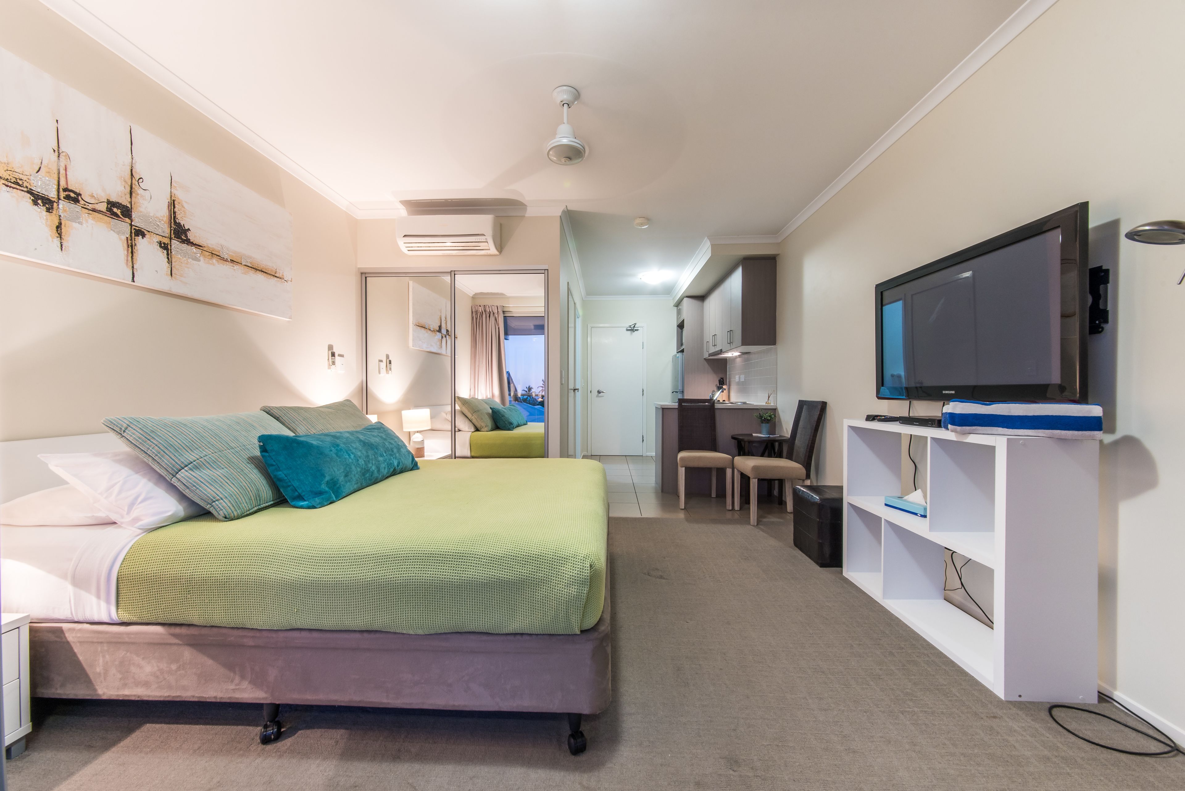 Ein modernes Schlafzimmer mit Bett, Fernseher und Schreibtisch.