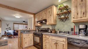 Une cuisine avec des meubles en bois, un lave-vaisselle Bosch et une machine à café.