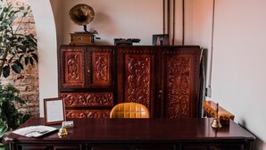 A wooden desk with a chair, a framed certificate, a small bell, and a gramophone on top. - Tierra Soñada Hotel Boutique (Tepatitlan de Morelos)