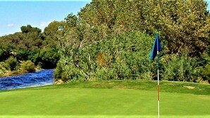 A golf course with a river, trees, and a mountain in the background. - Rodeway Inn Copper Stay Benson AZ I-10 Exit 304 (Benson)