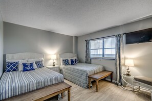 A bedroom with two beds, a TV mounted on the wall, and a window with curtains. - 🌟Oceanfront~Pool~Courtyard Area~ Arcadian 12CD🌟 (Myrtle Beach)
