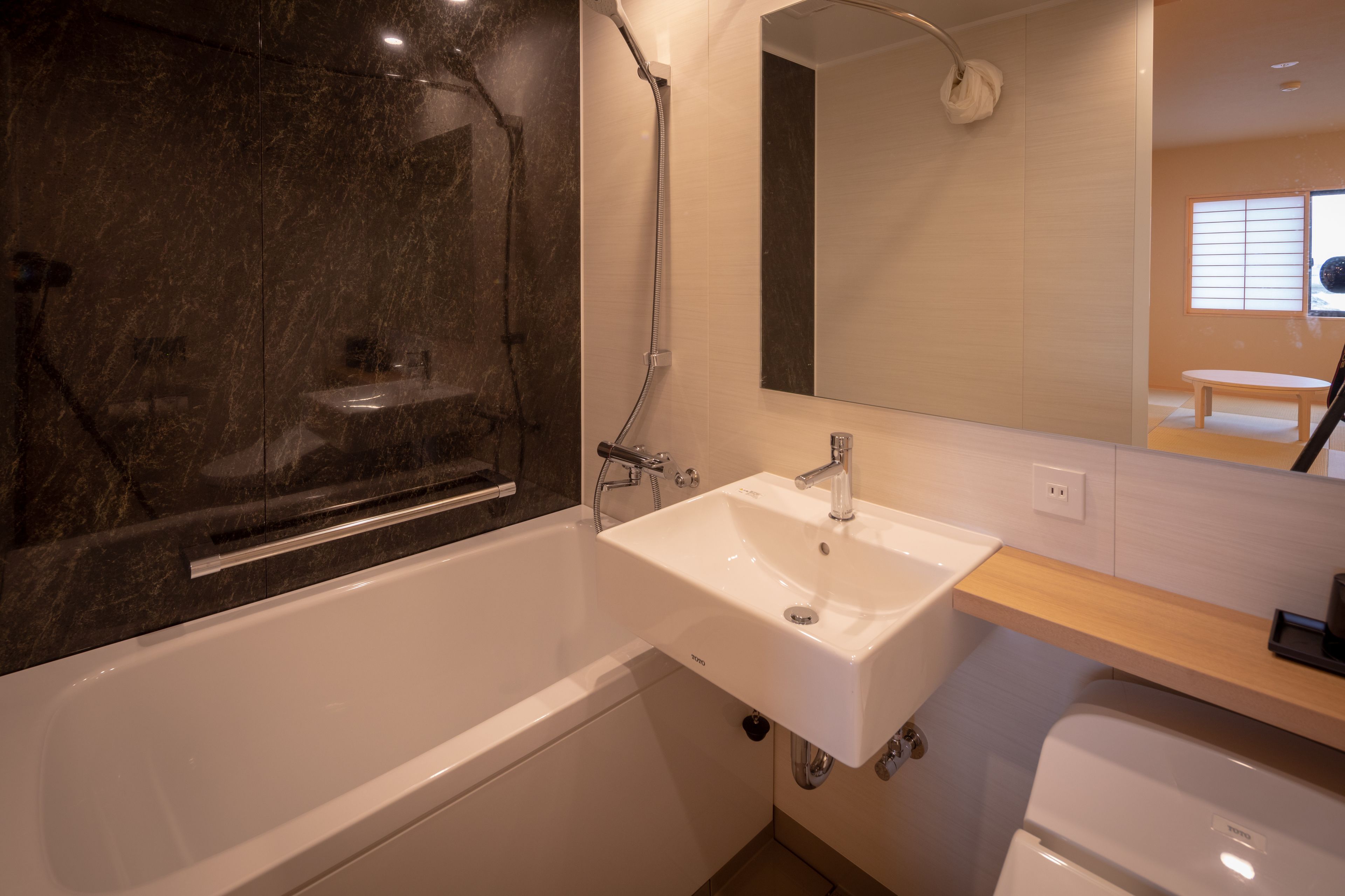 Une salle de bain moderne avec une baignoire, un lavabo et un miroir.