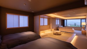 A modern hotel room with two beds, a small sitting area, and a view of the sea. - Imigre (Himi)